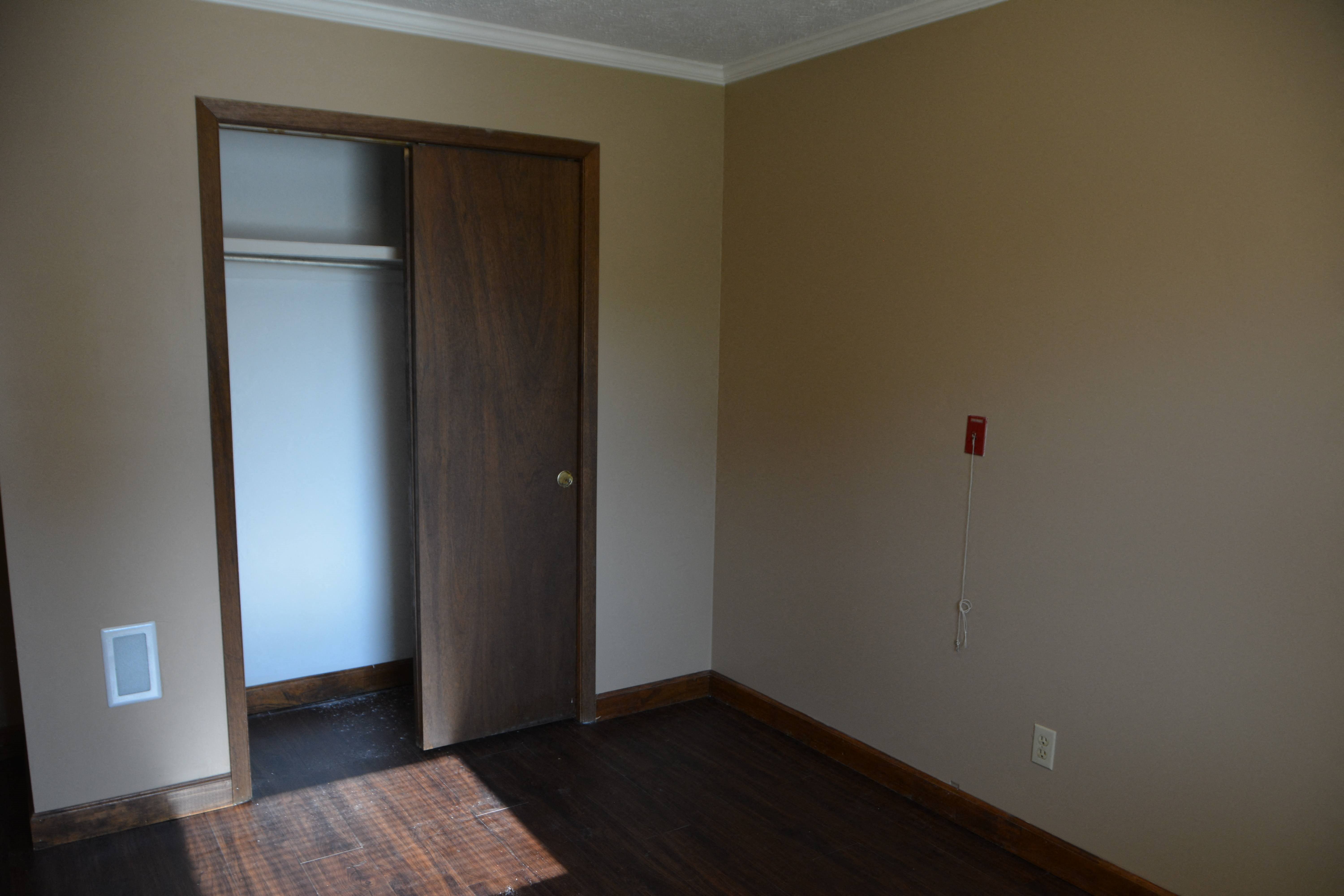an empty living room with a door to a closet