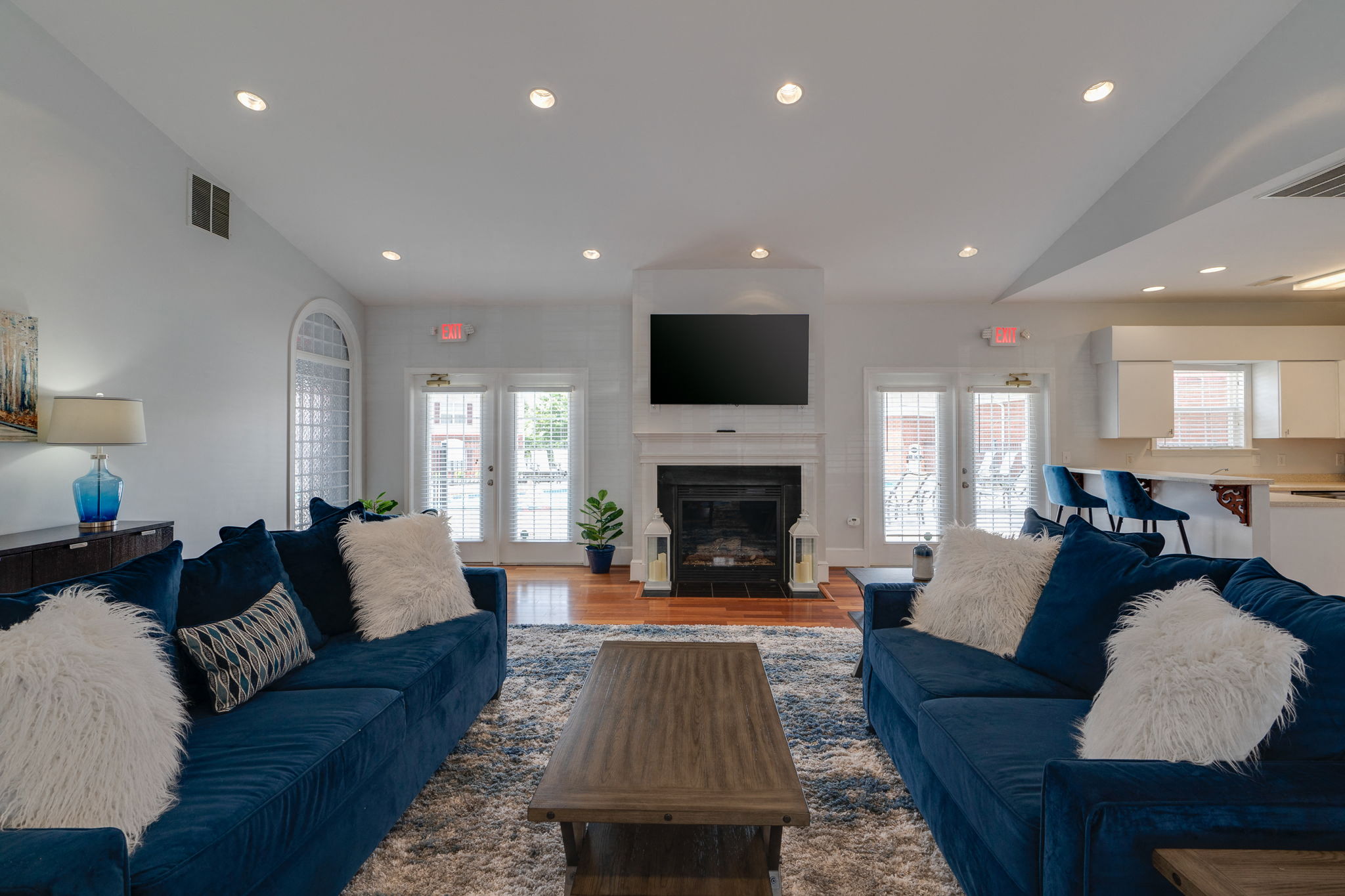a large living room with blue couches and a fireplace