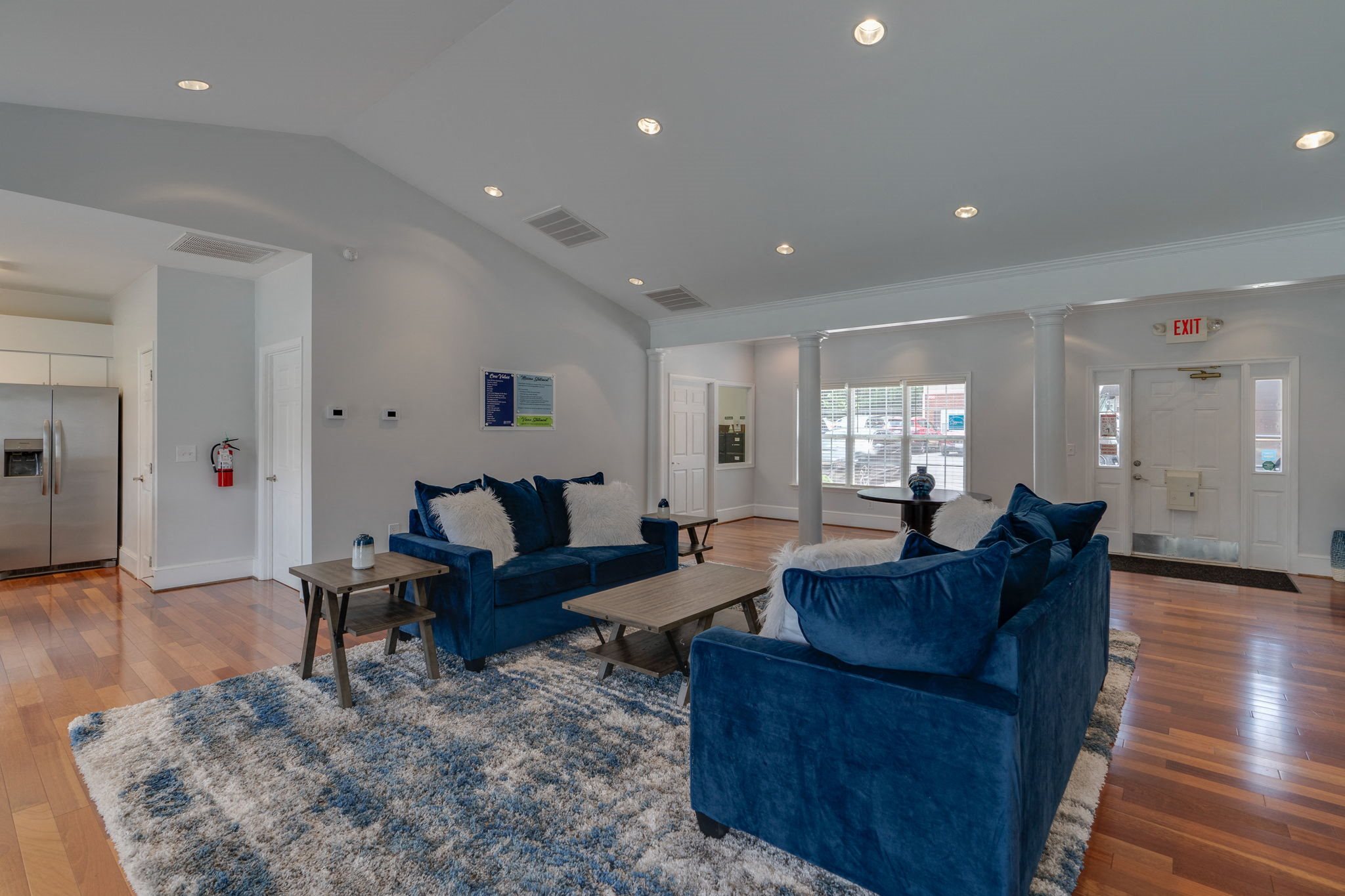a living room with two blue couches and a rug
