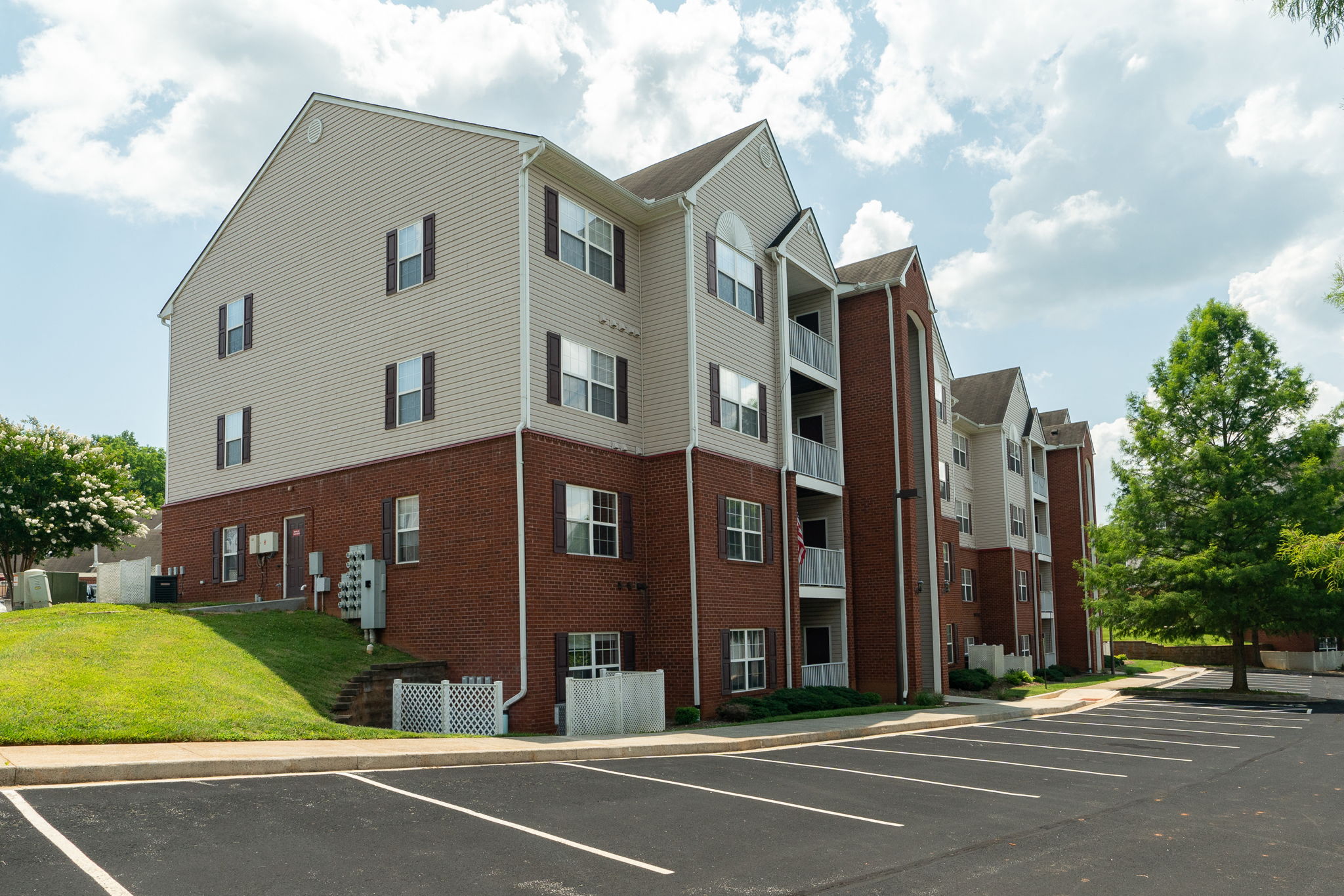 an apartment building on the corner of a parking lot