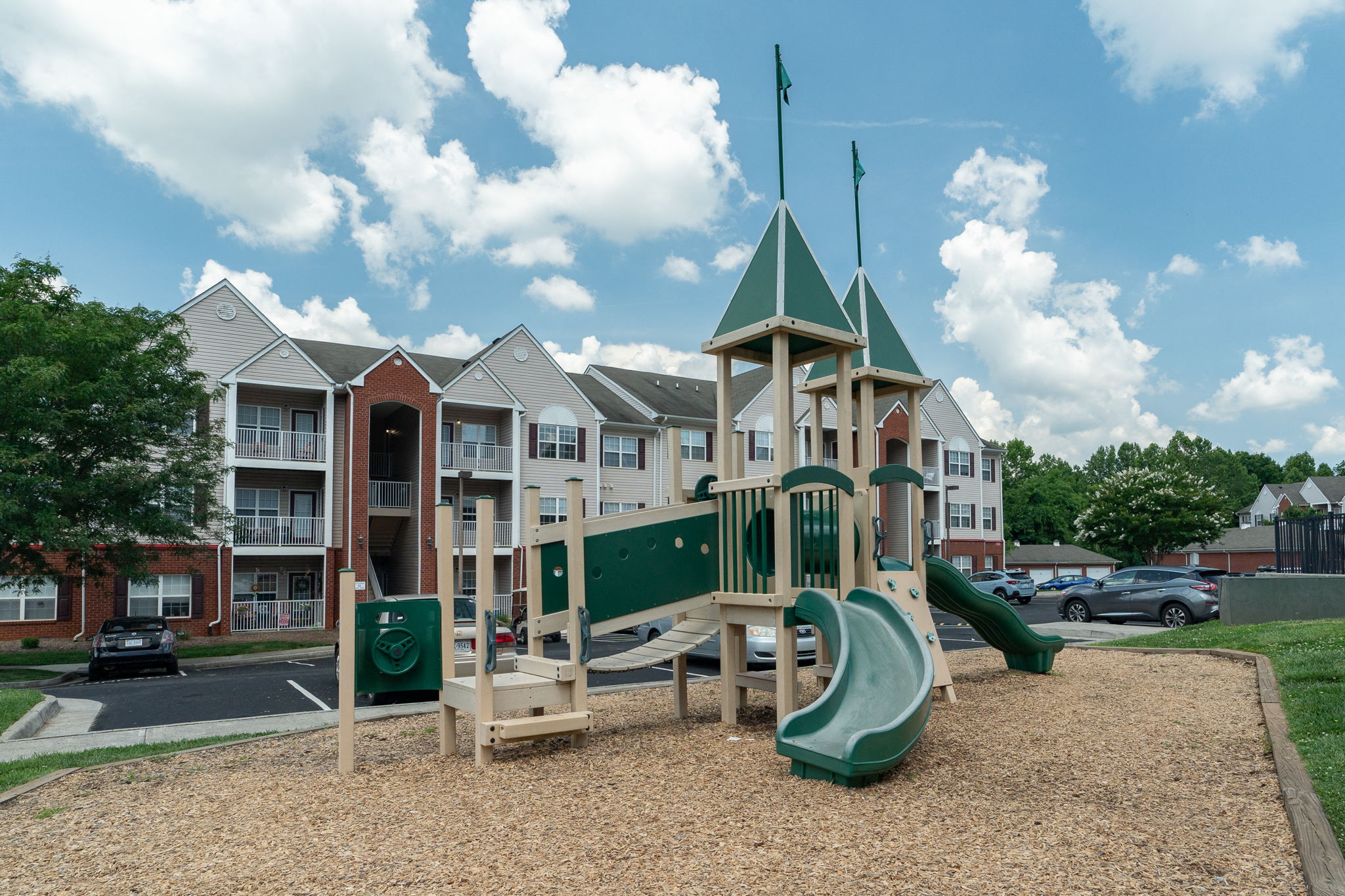 a playground with slides in front of an apartment building