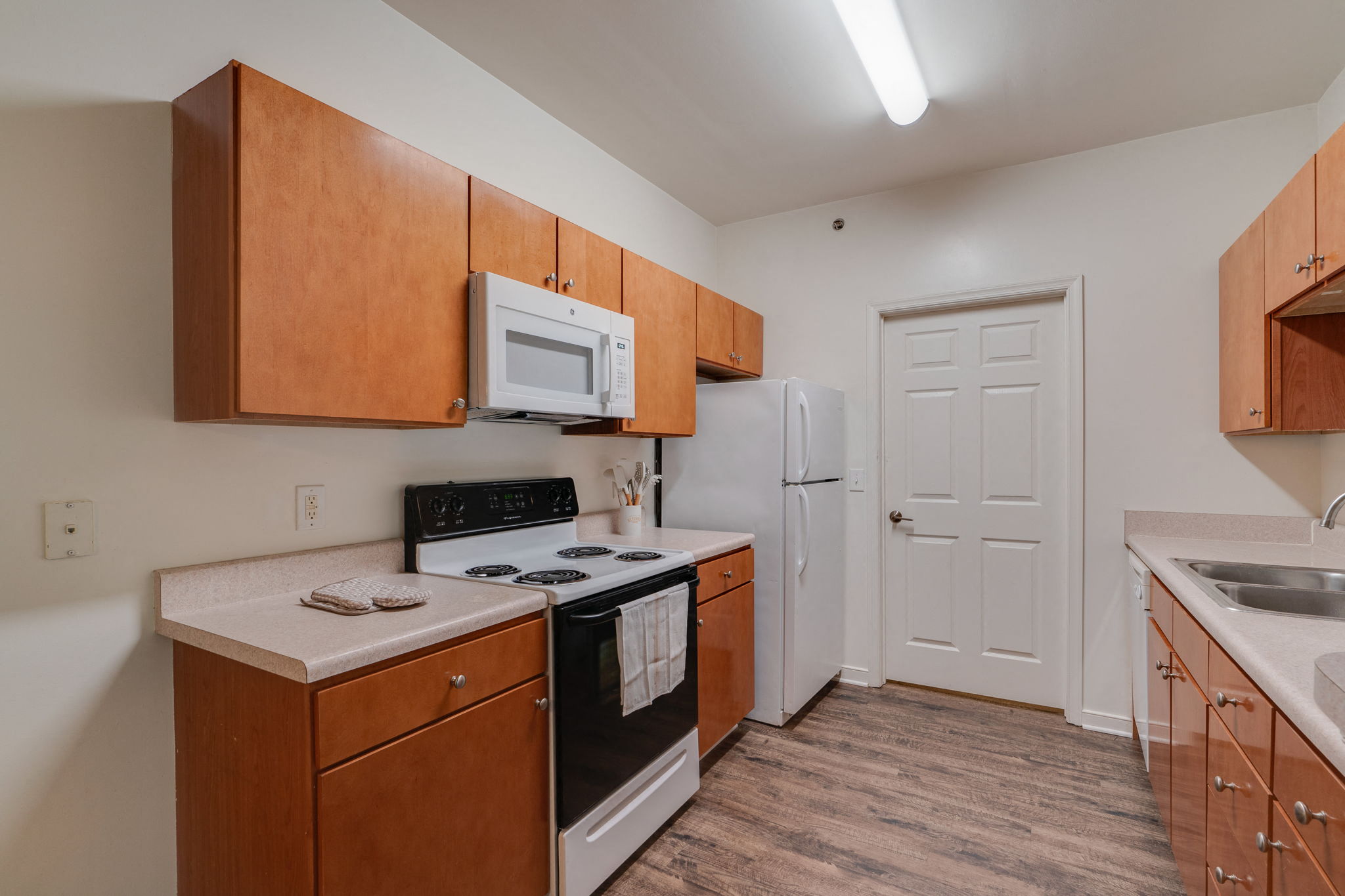 a kitchen with wooden cabinets and white appliances and a white refrigerator