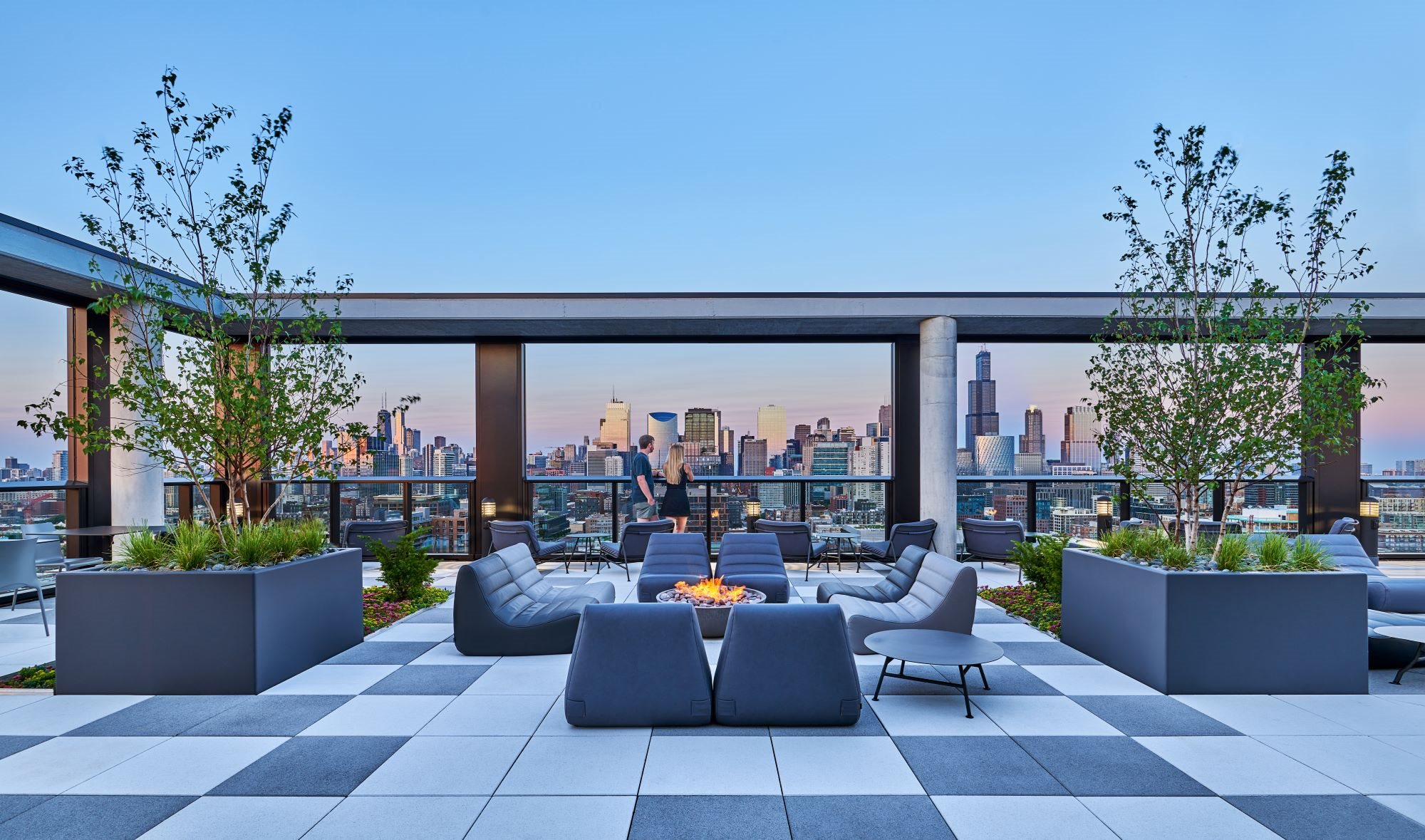 a rendering of a rooftop lounge with a city skyline in the background