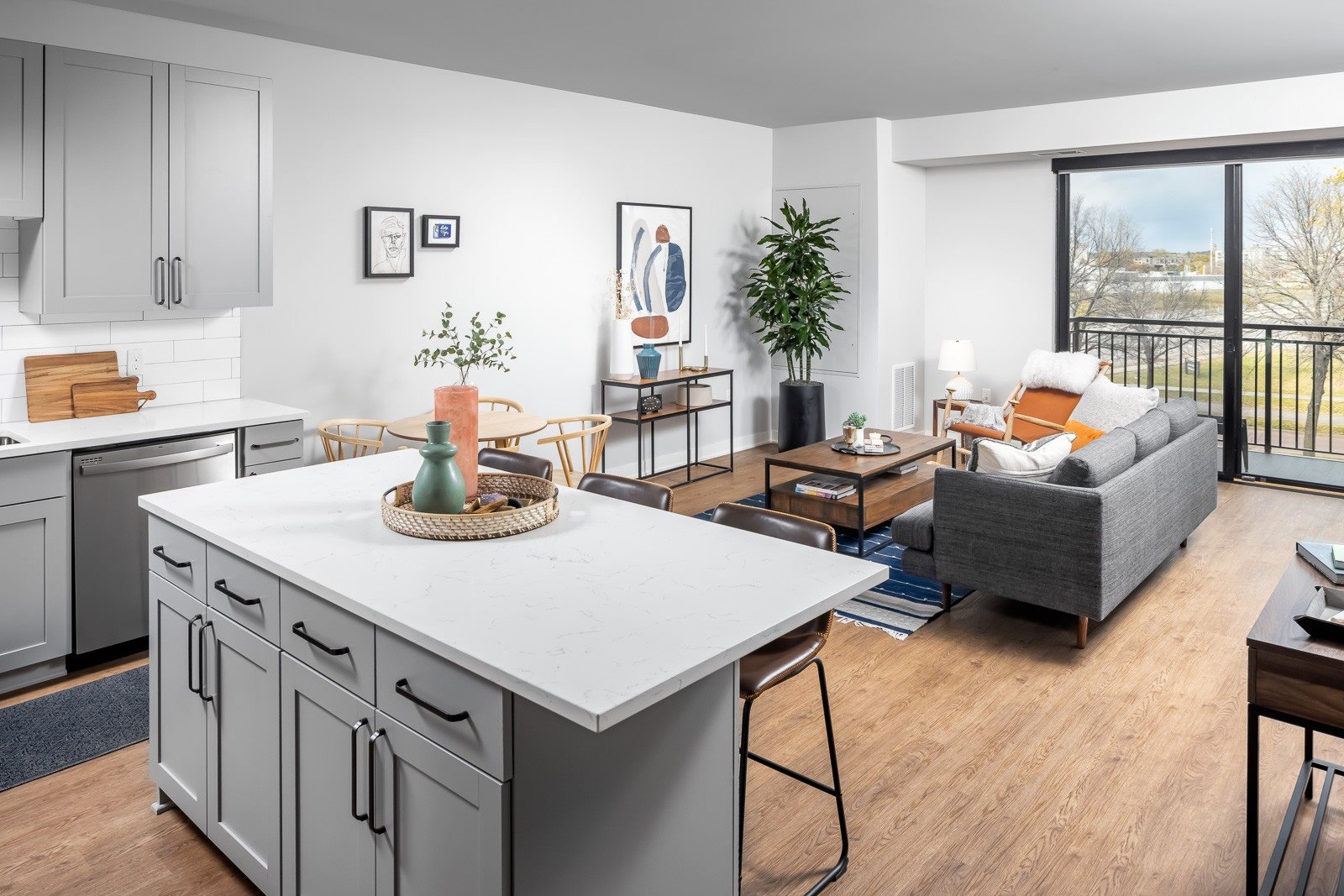 Kitchen island and living room with balcony in one bedroom apartment