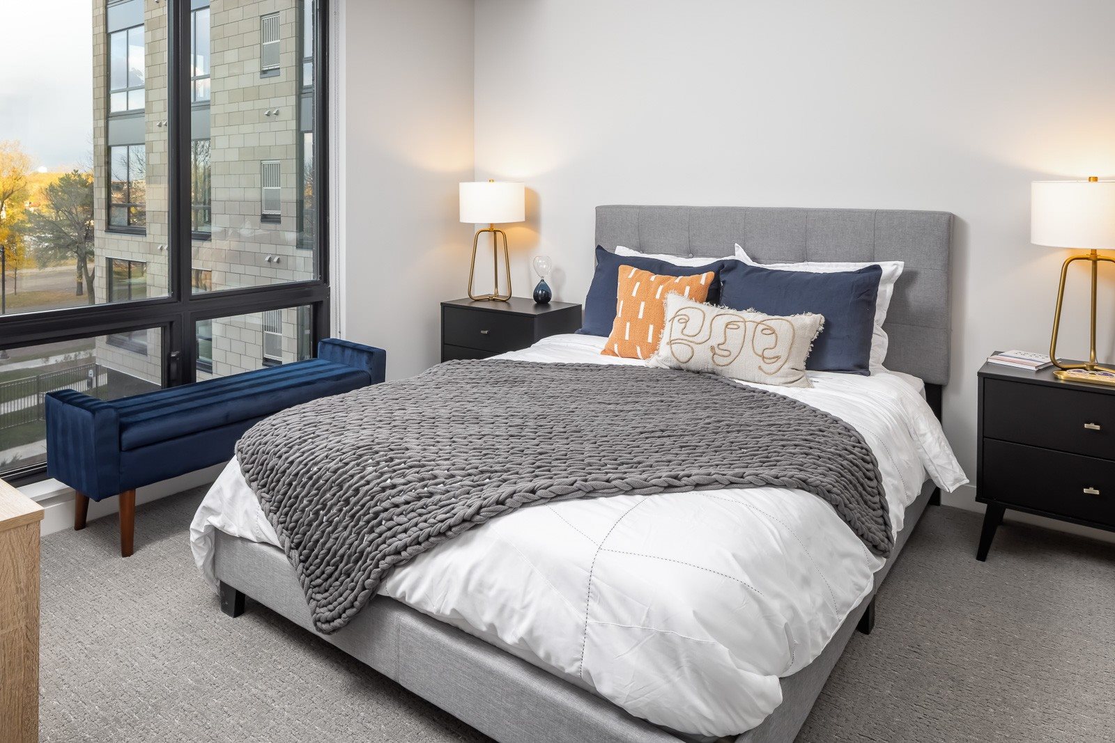 Spacious bedroom with large windows overlooking river in one bedroom apartment