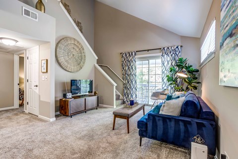Legacy at Fox Valley Living Room with Plush Carpet Flooring and Sliding Glass Door Access to Patio or Balcony