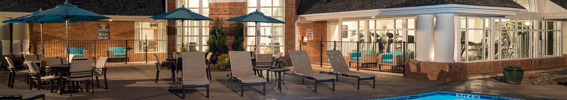 A poolside area with chairs and umbrellas.