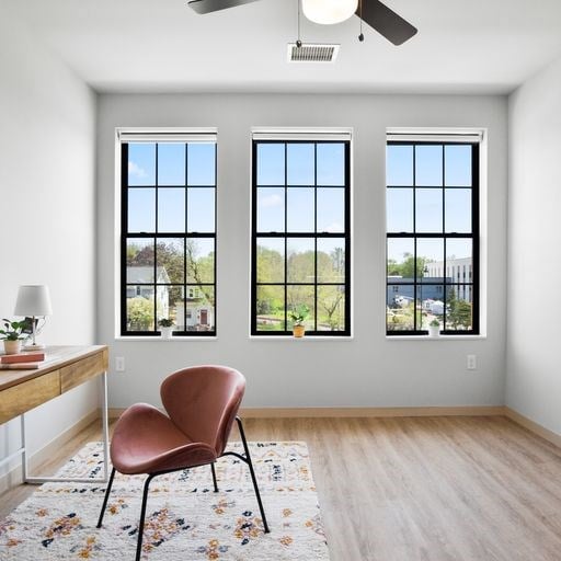 a living room with four windows and a chair