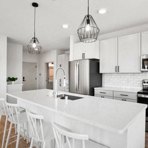 a kitchen with a large white island and white chairs