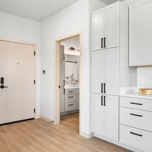 a white kitchen with white cabinets and a white sink