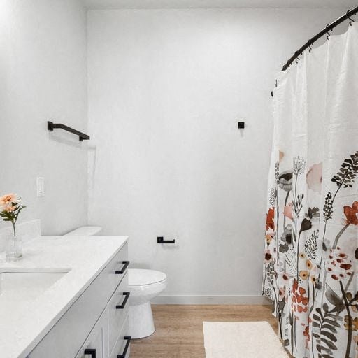 a bathroom with a toilet sink and shower curtain