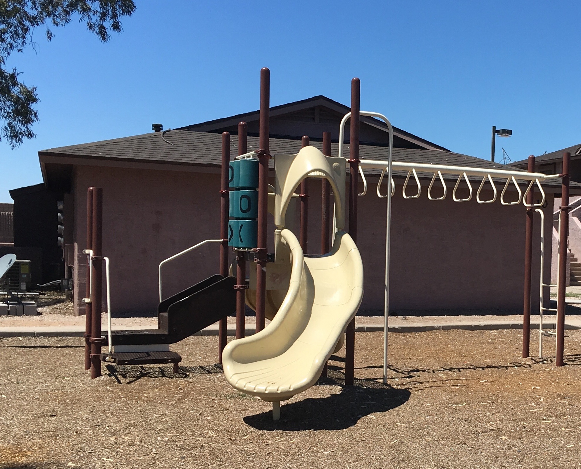 a slide at a playground in front of a building