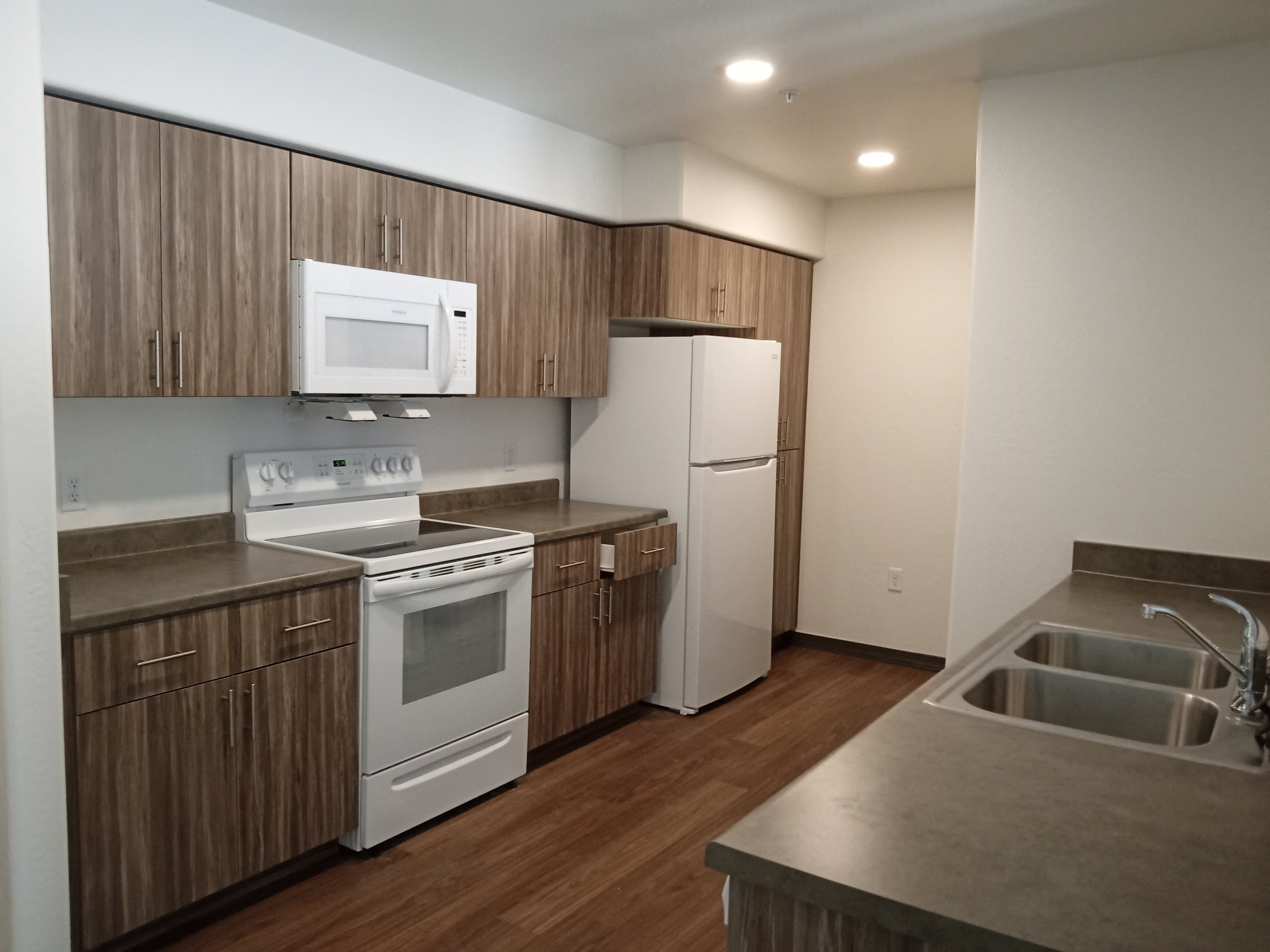 a kitchen with white appliances and wooden cabinets