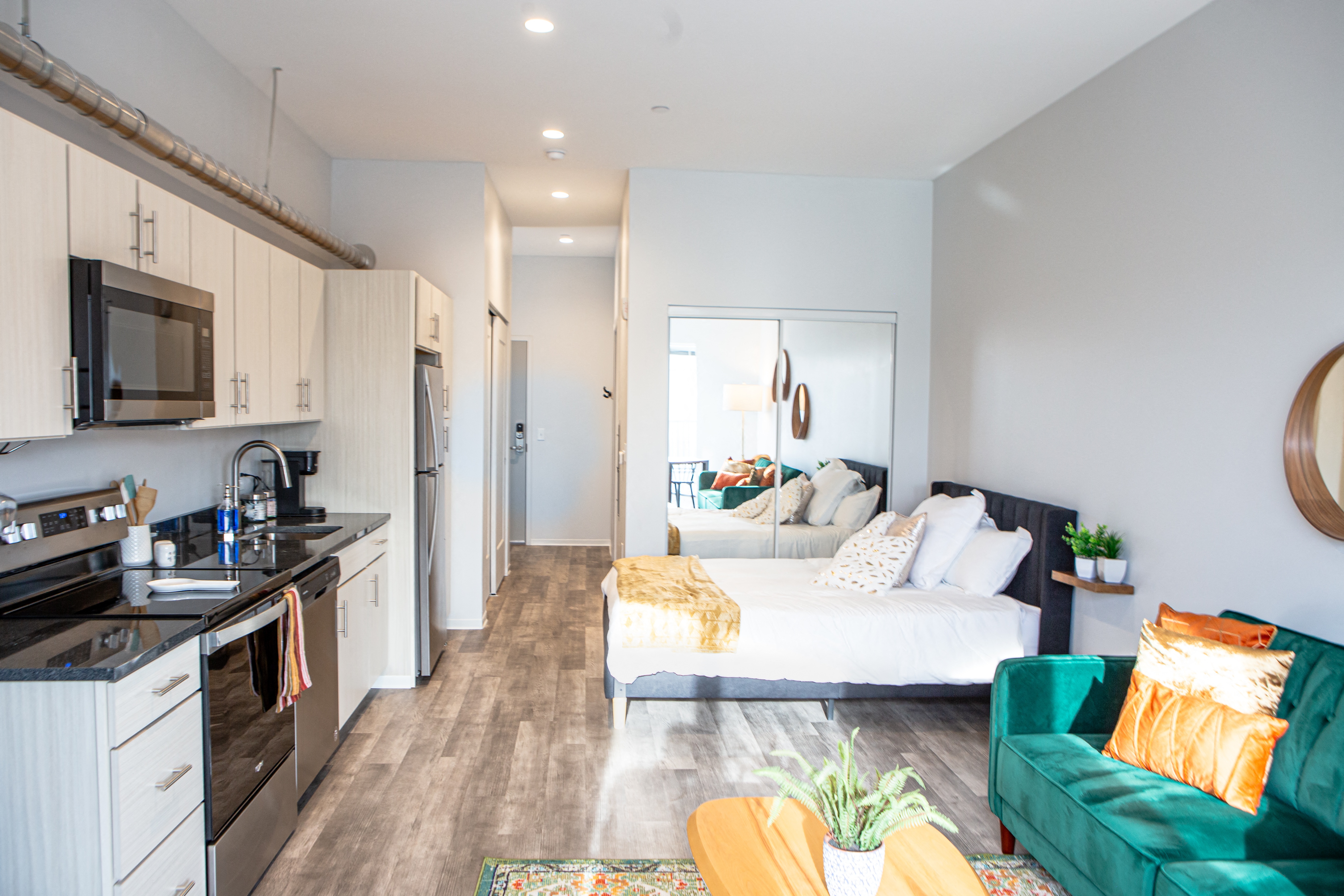 a bedroom with a bed and a kitchen and a living room