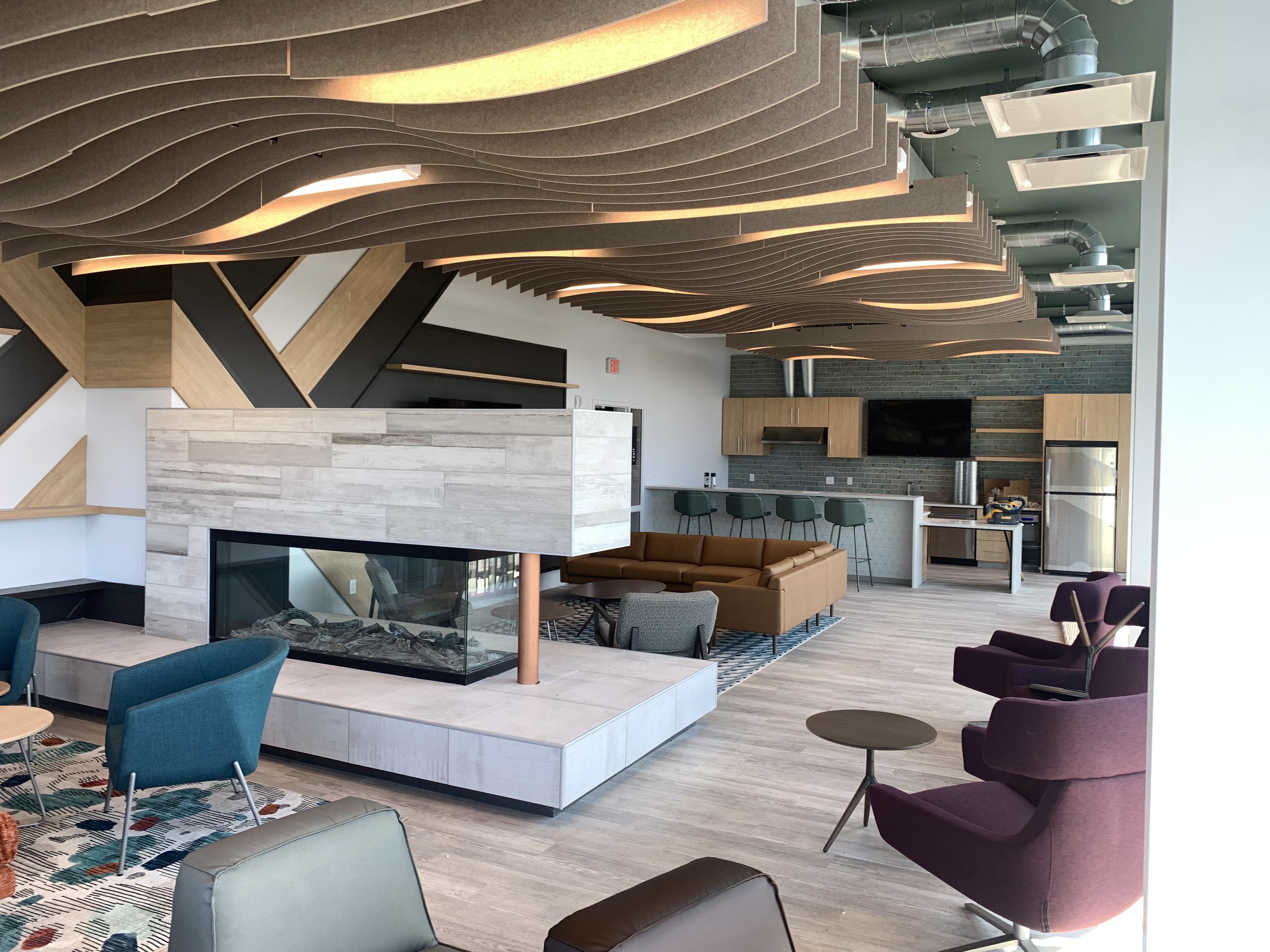 a living room with a fireplace and a suspended ceiling