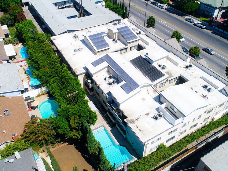 Aerial drone picture of the building showing solar panels and white energy-efficient roof.