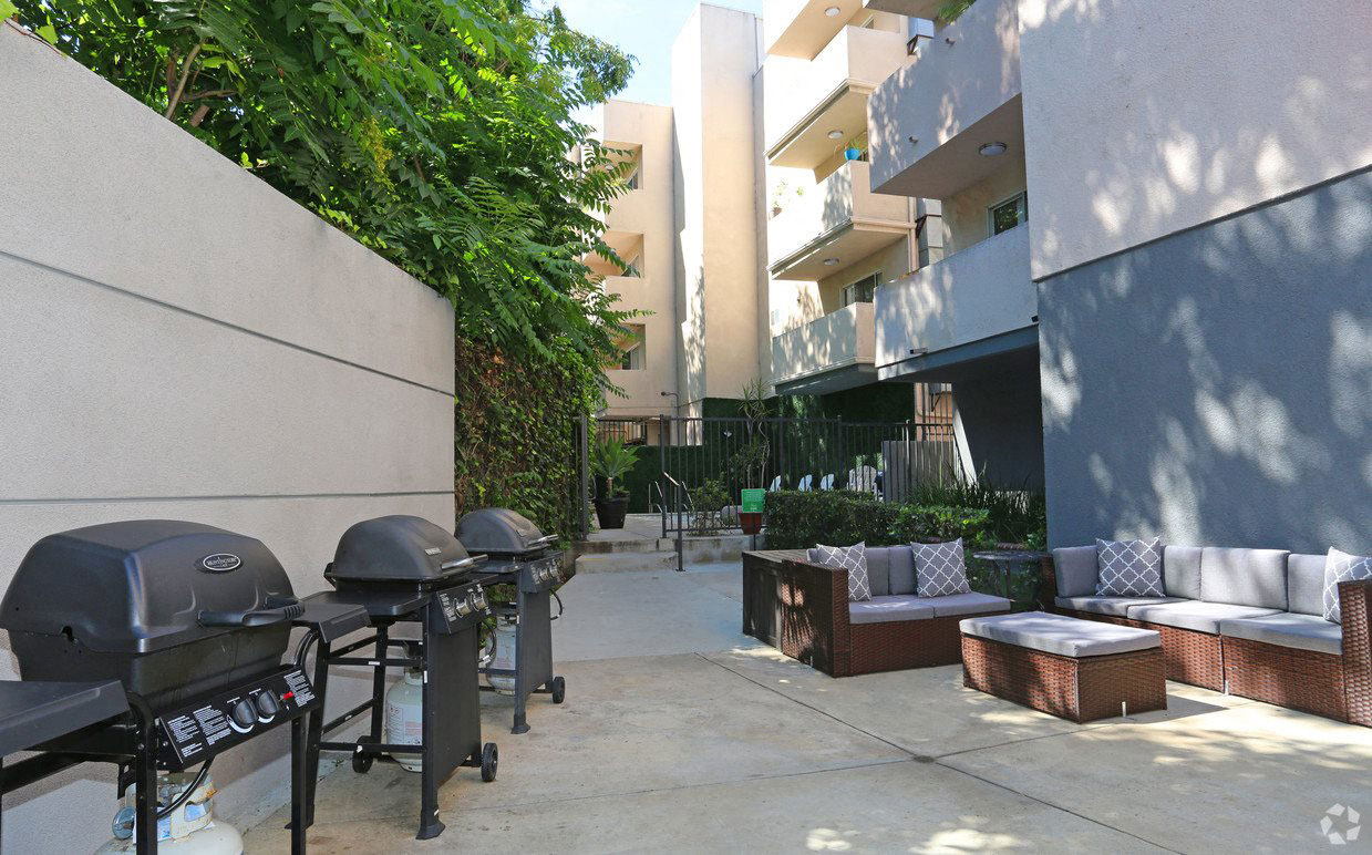 Courtyard view of community seating area next to barbecues.