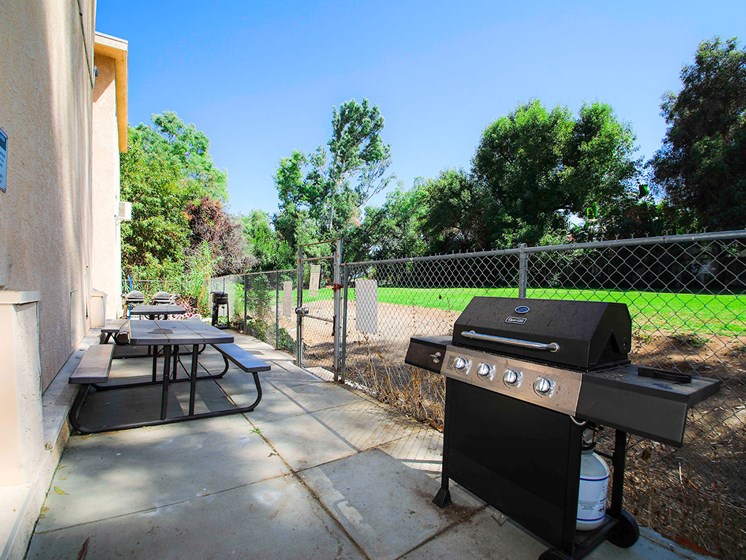 Outdoor barbeque space adjacent and connected to neighboring park space.