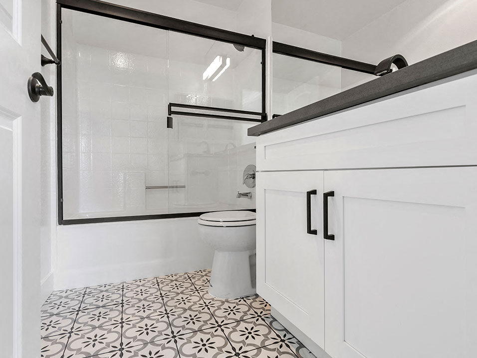 White bathroom with shower, tub, and tiled floor.