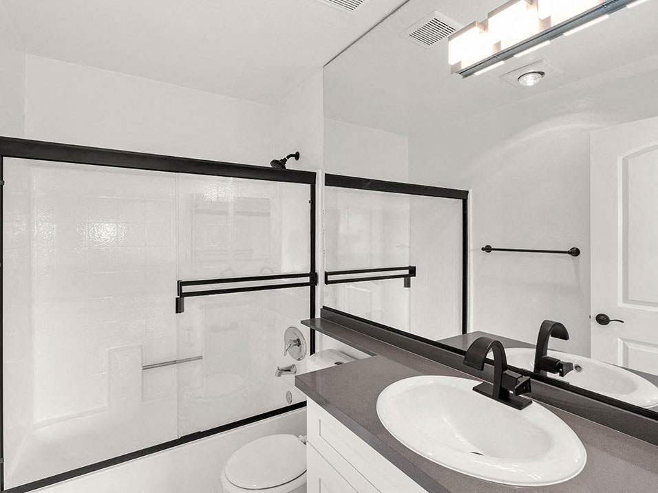 White bathroom with modern fixtures, shower, and tub.