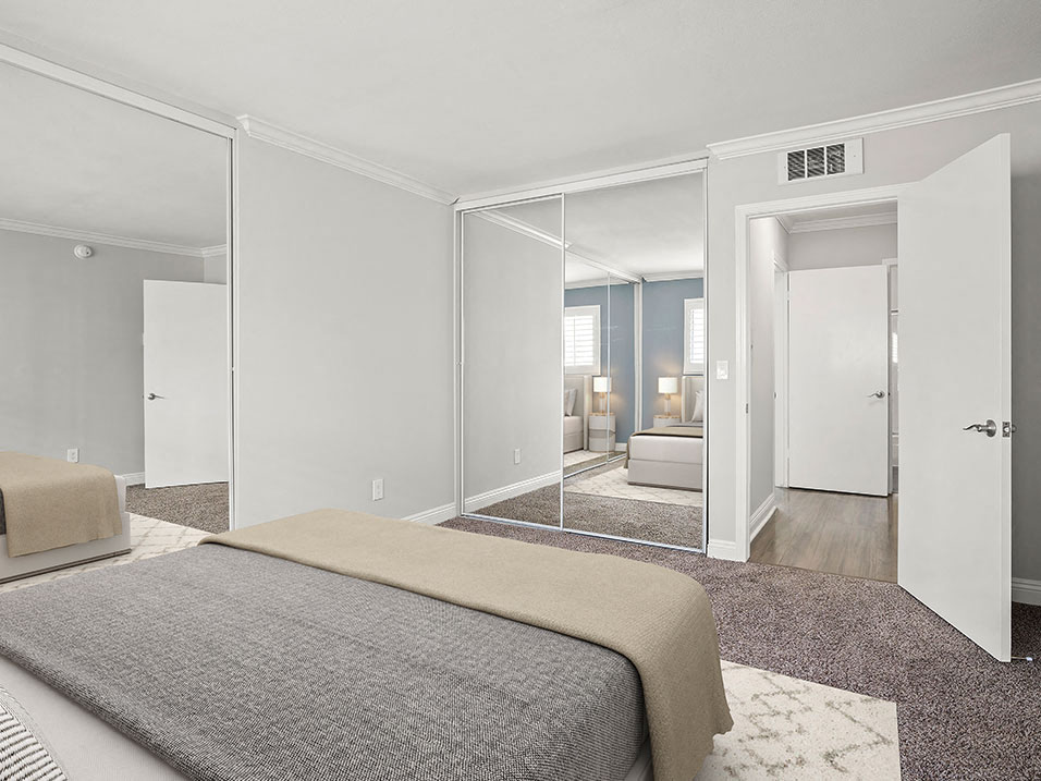 Carpeted bedroom with copious closet space.