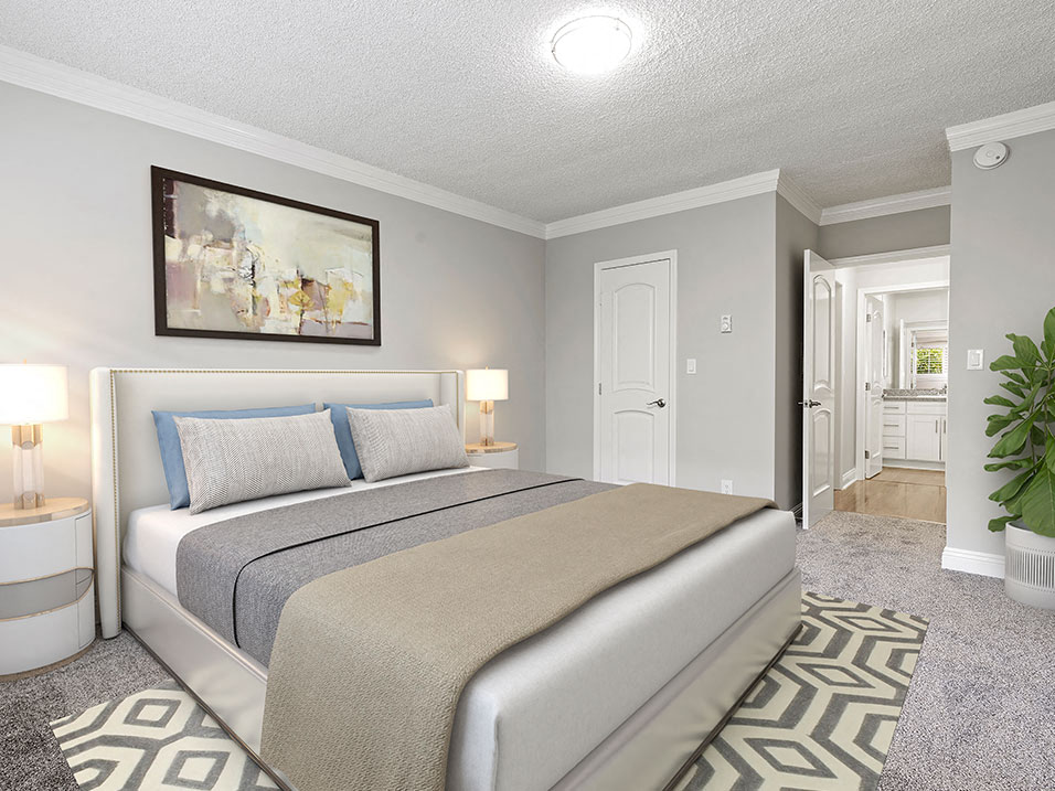 Well-lit carpeted bedroom with private bathroom.