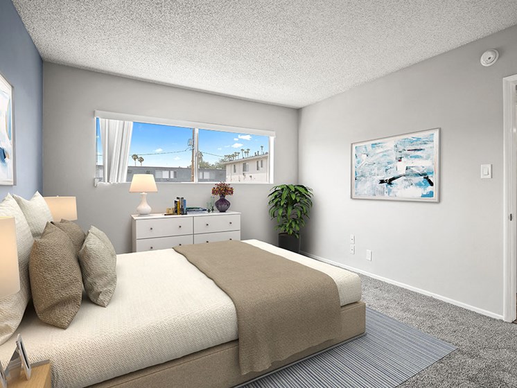 Carpeted bedroom with large window for natural light.