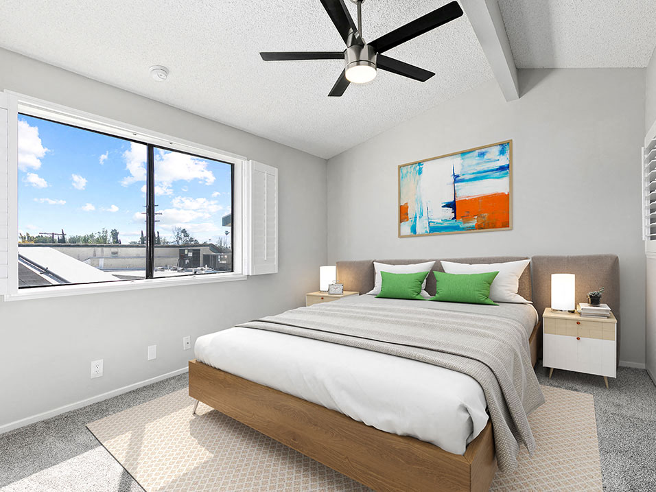 Carpeted bedroom with ceiling fan and large window for natural light.