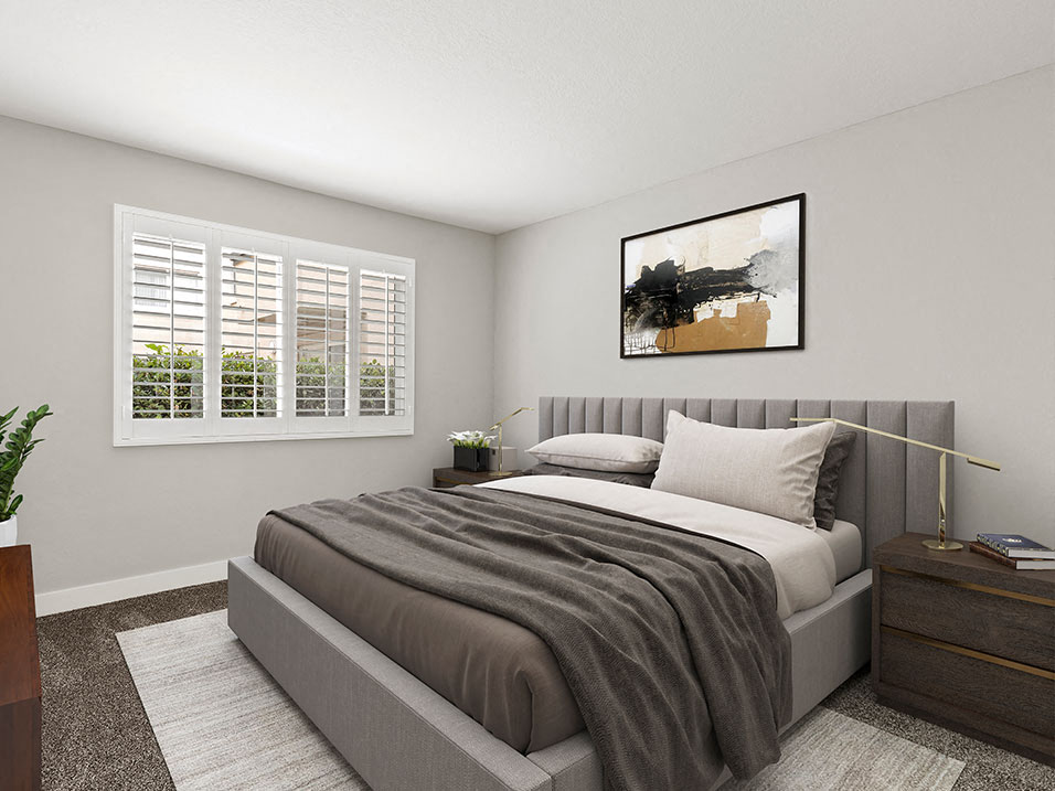 Carpeted bedroom with large natural light windows.