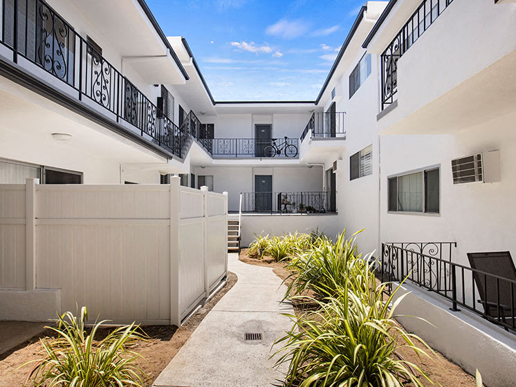 Green outdoor courtyard depicting access to walk-up units.