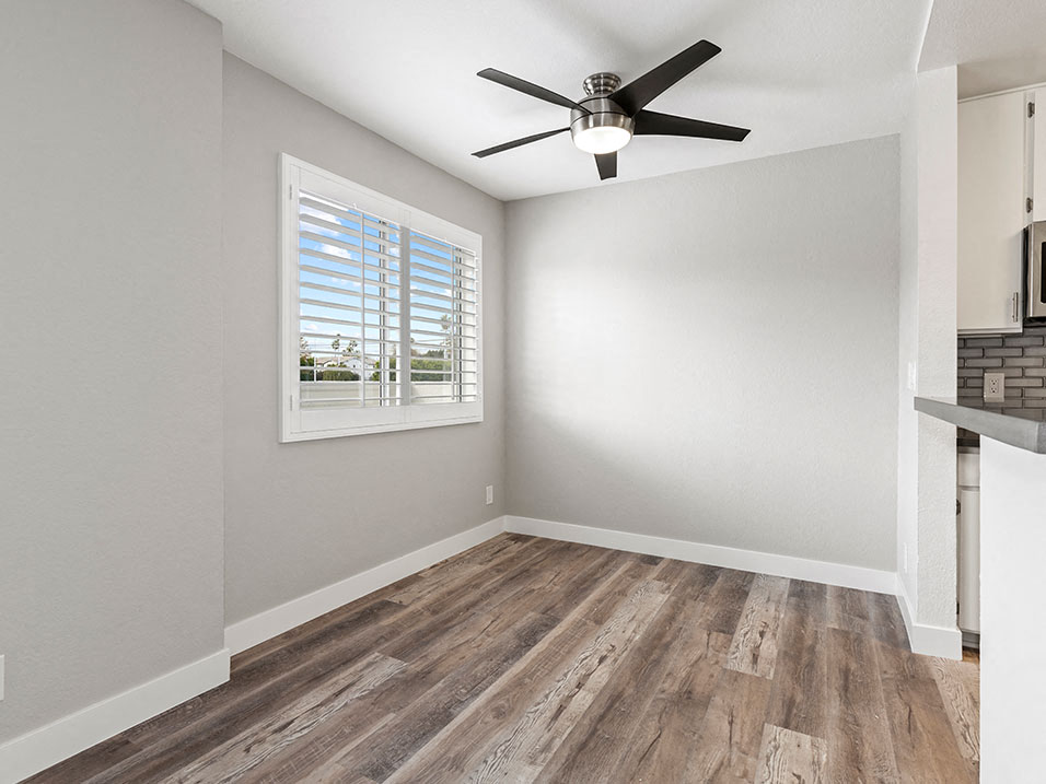 Hardwood floored dining room with ceiling fan.