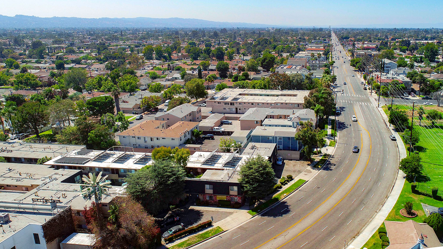 Aerial drone photo of 10620 NoHo showing solar panels and energy-efficient white roofing.
