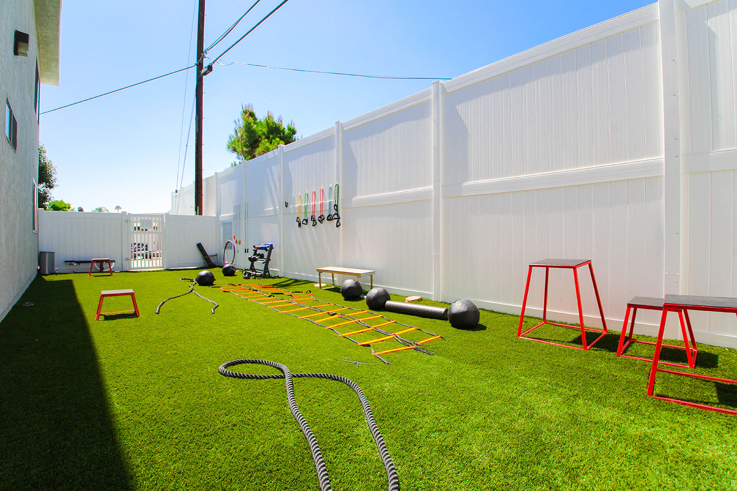 Outdoor fitness center with free weights, jump ropes, and medicine balls.