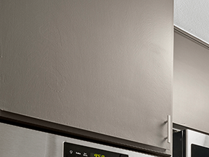 Blue tiled kitchen with stainless steel oven, microwave, fridge, and fixtures.
