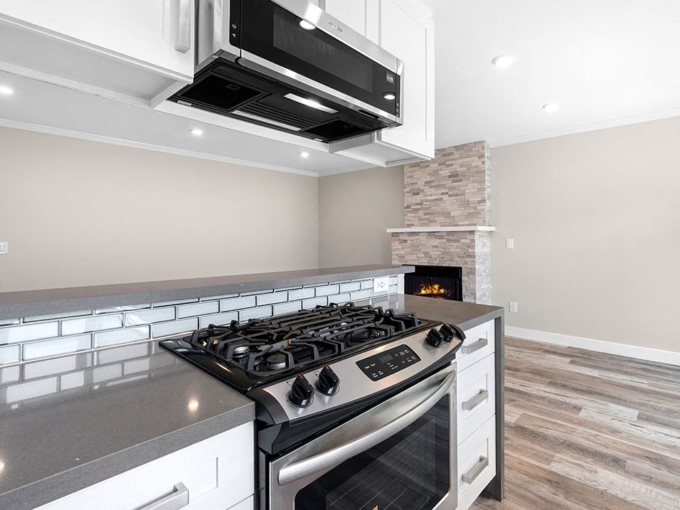 Blue tiled kitchen with stainless steel oven, fridge, dish washer, and fixtures.