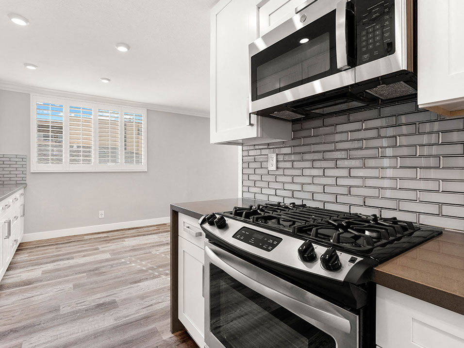 Wrap around kitchen with stainless steel microwave and oven.