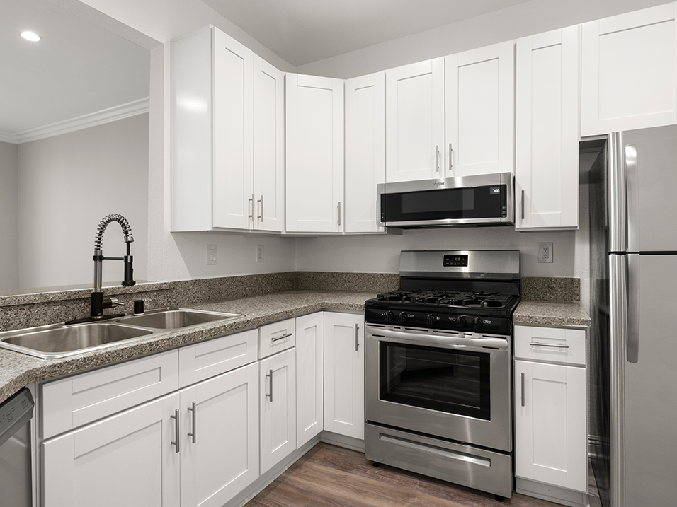 Kitchen with stainless steel fridge, oven, and microwave.