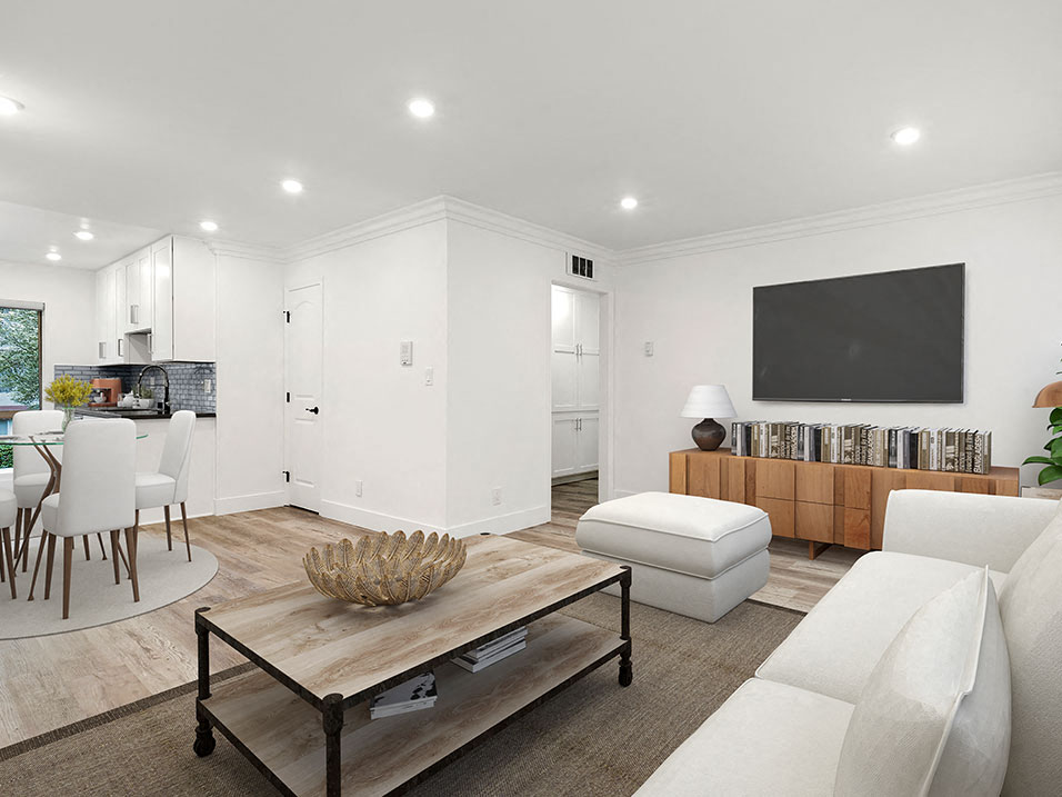 Large hardwood floored living room with view to kitchen and hallway storage.