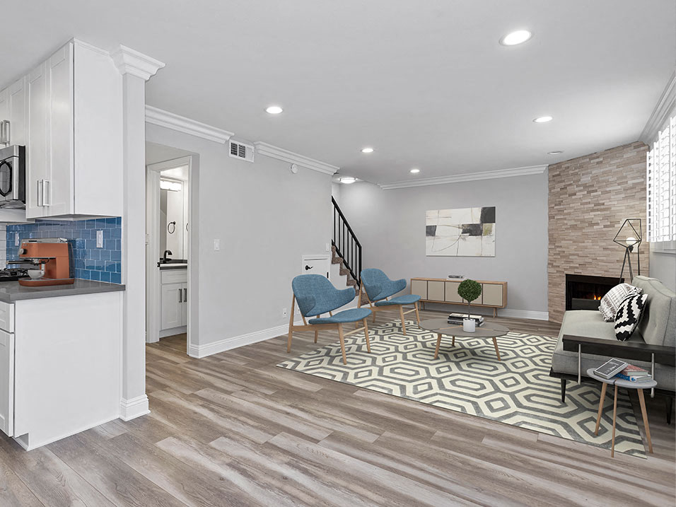 Brightly lit living room with stone walled fireplace.