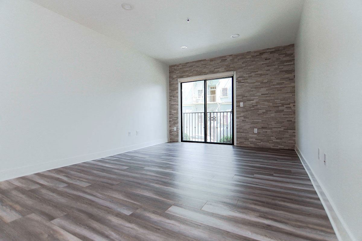 Living room with stone accent wall and view of balcony.