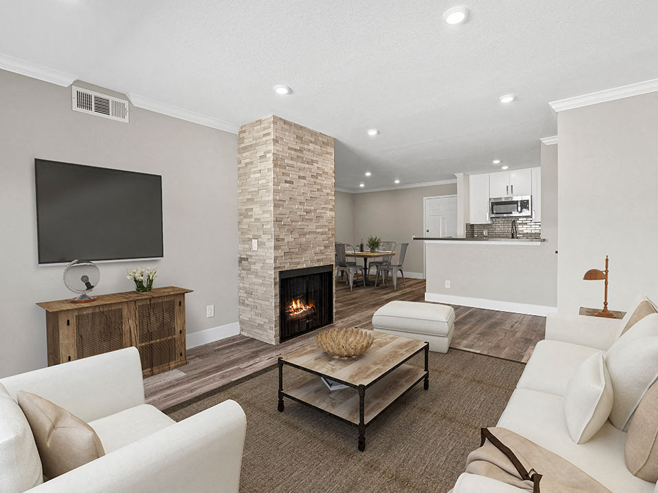 Living room with stone accented fireplace and mounted television.