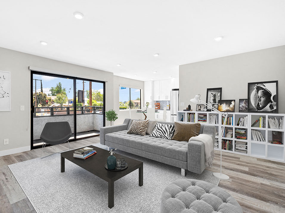 Large hardwood floored living rooms with can lights and view of balcony.