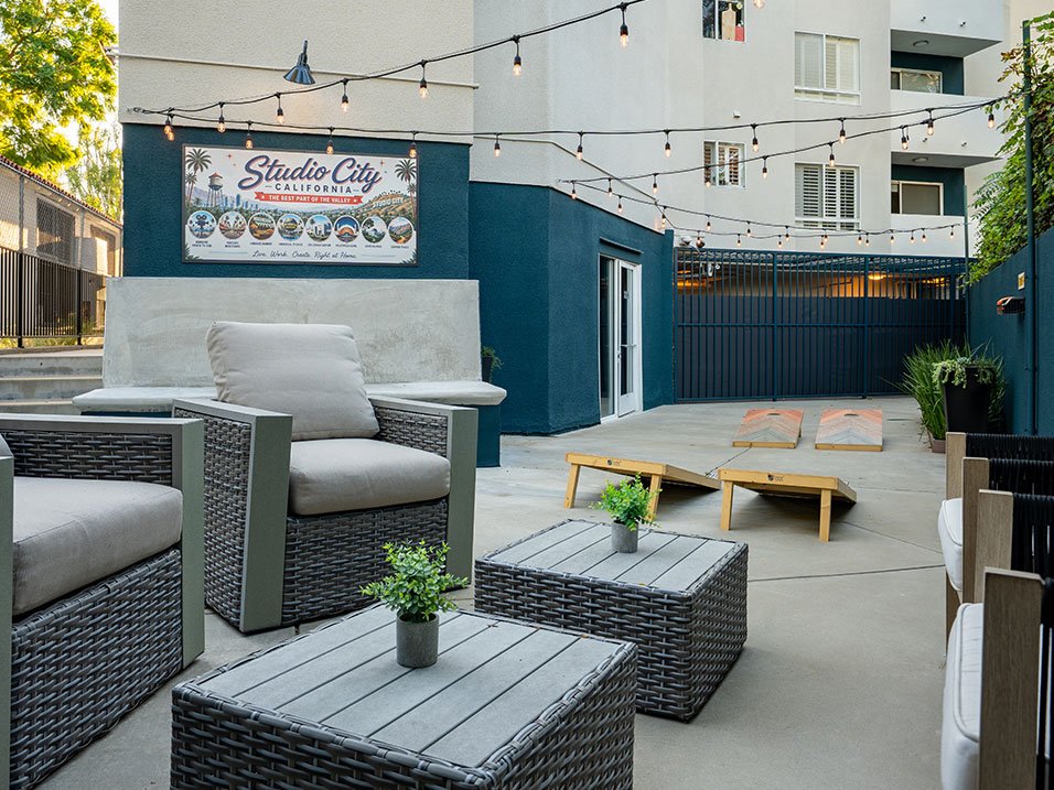 Rear courtyard seating area with visible cornhole.