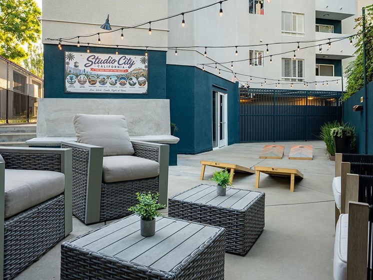 Rear courtyard seating area with visible cornhole.