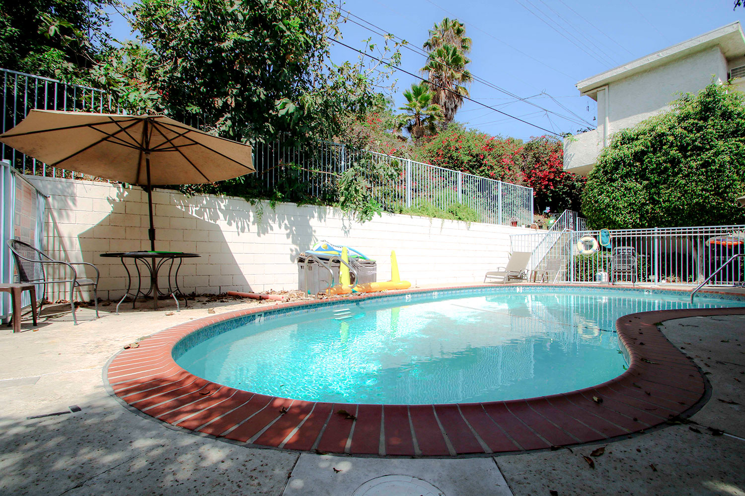 Gated swimming pool with  seating area.
