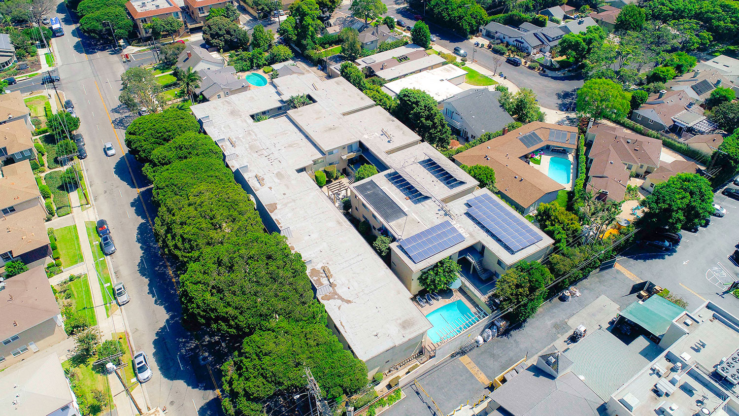 Aerial drone view of National Apartments depicting roof-mounted solar panels and adjacency to Whole Foods Market.