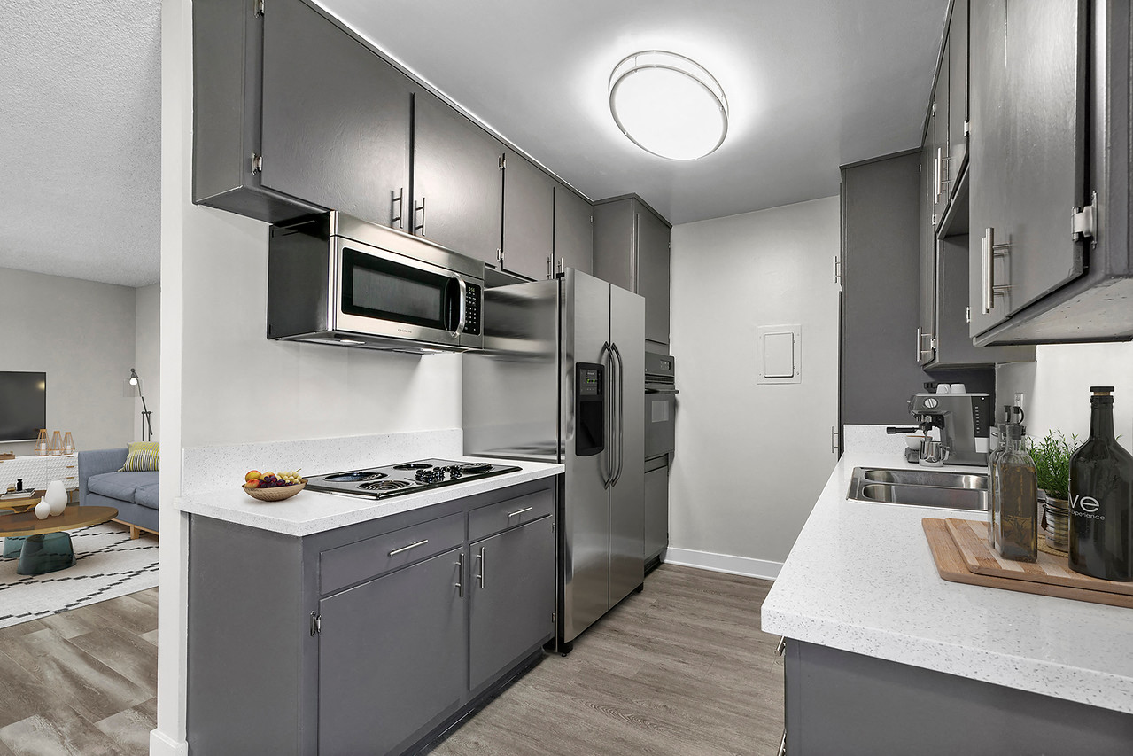 Spacious kitchen with stainless steel fridge, oven, and microwave.