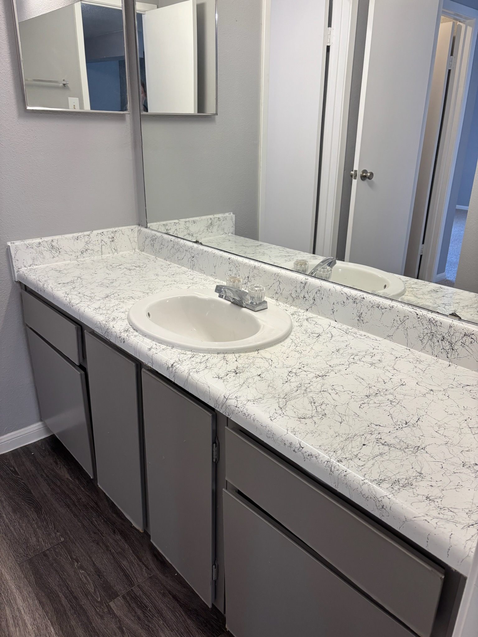 A bathroom with a marble countertop and a white sink.