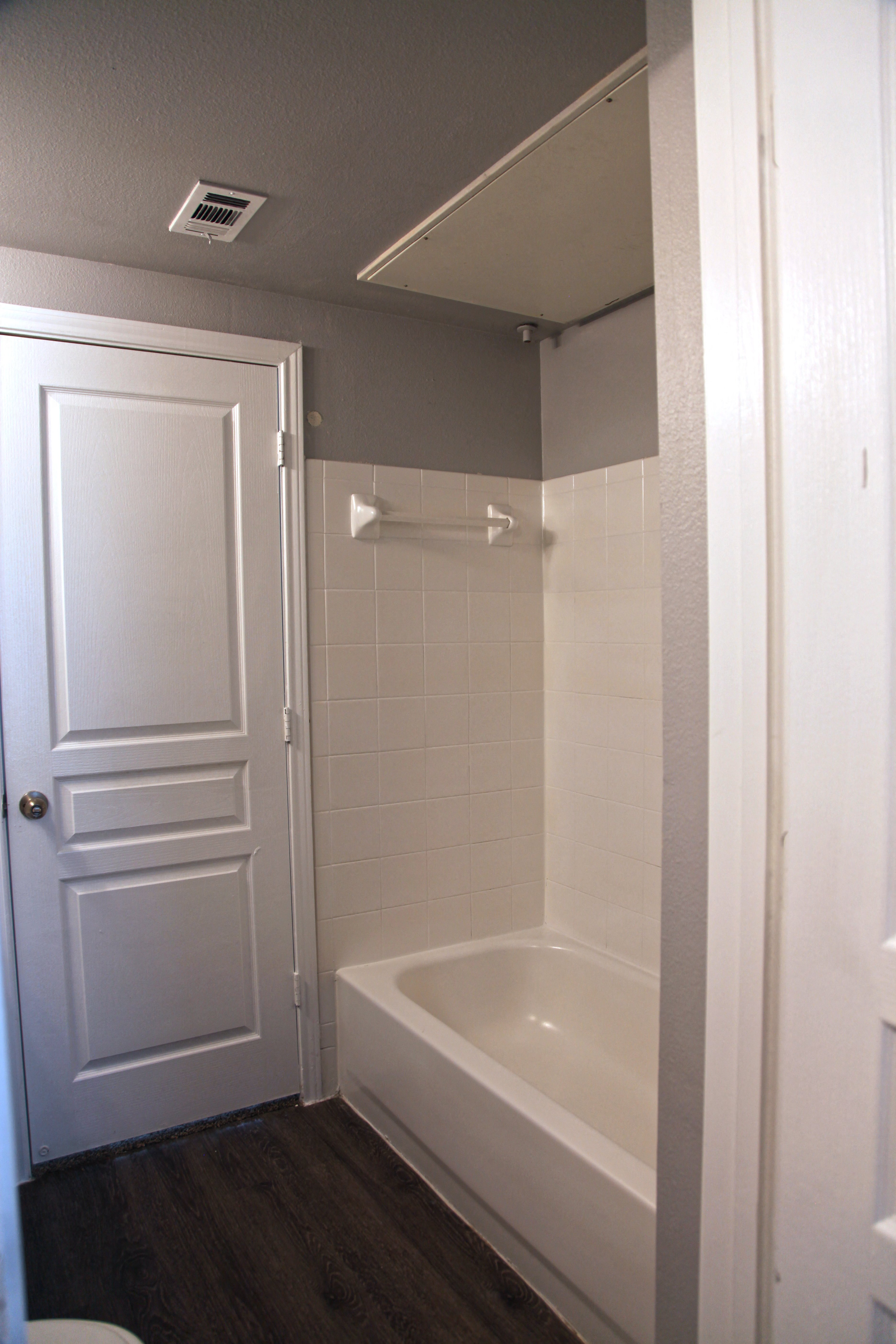 a small bathroom with a tub and a door