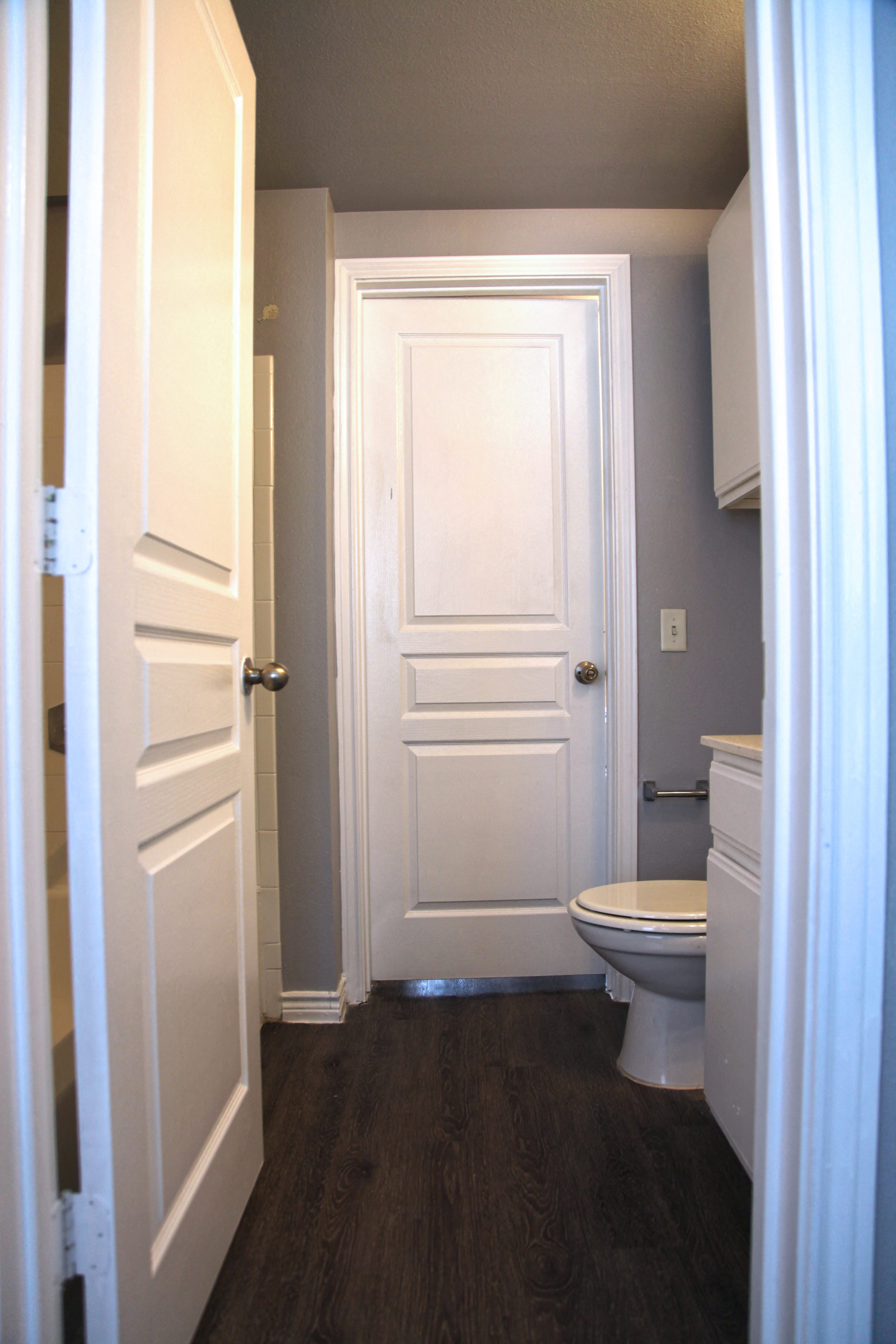 a small bathroom with a white door and a toilet